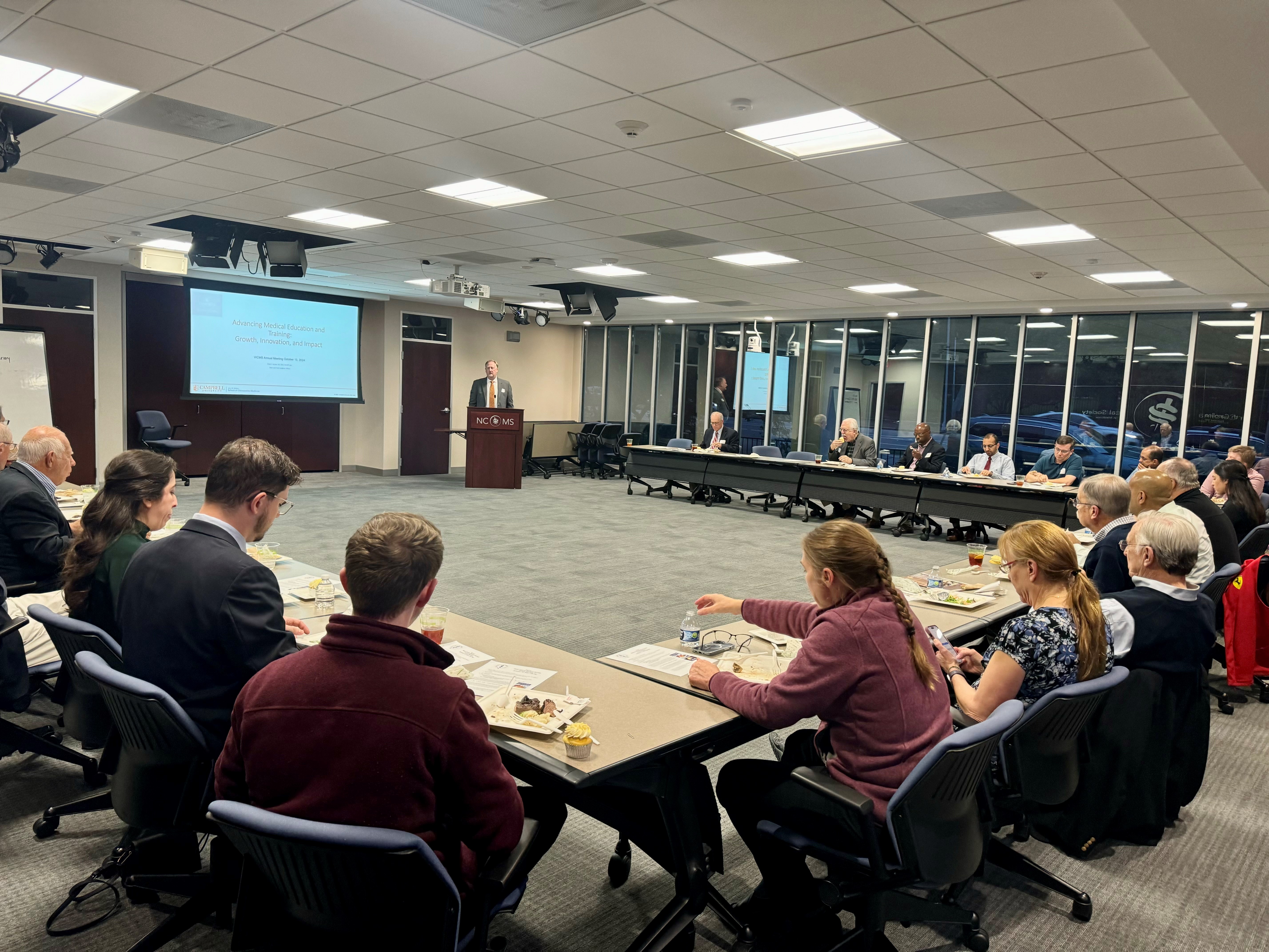 WCMS October 2024 meeting - photo of meeting attendees around a U-shaped desk